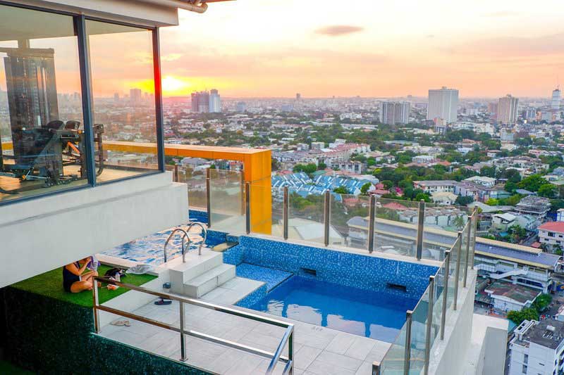 A high-floor view overlooking a pool and a cityscape with numerous buildings